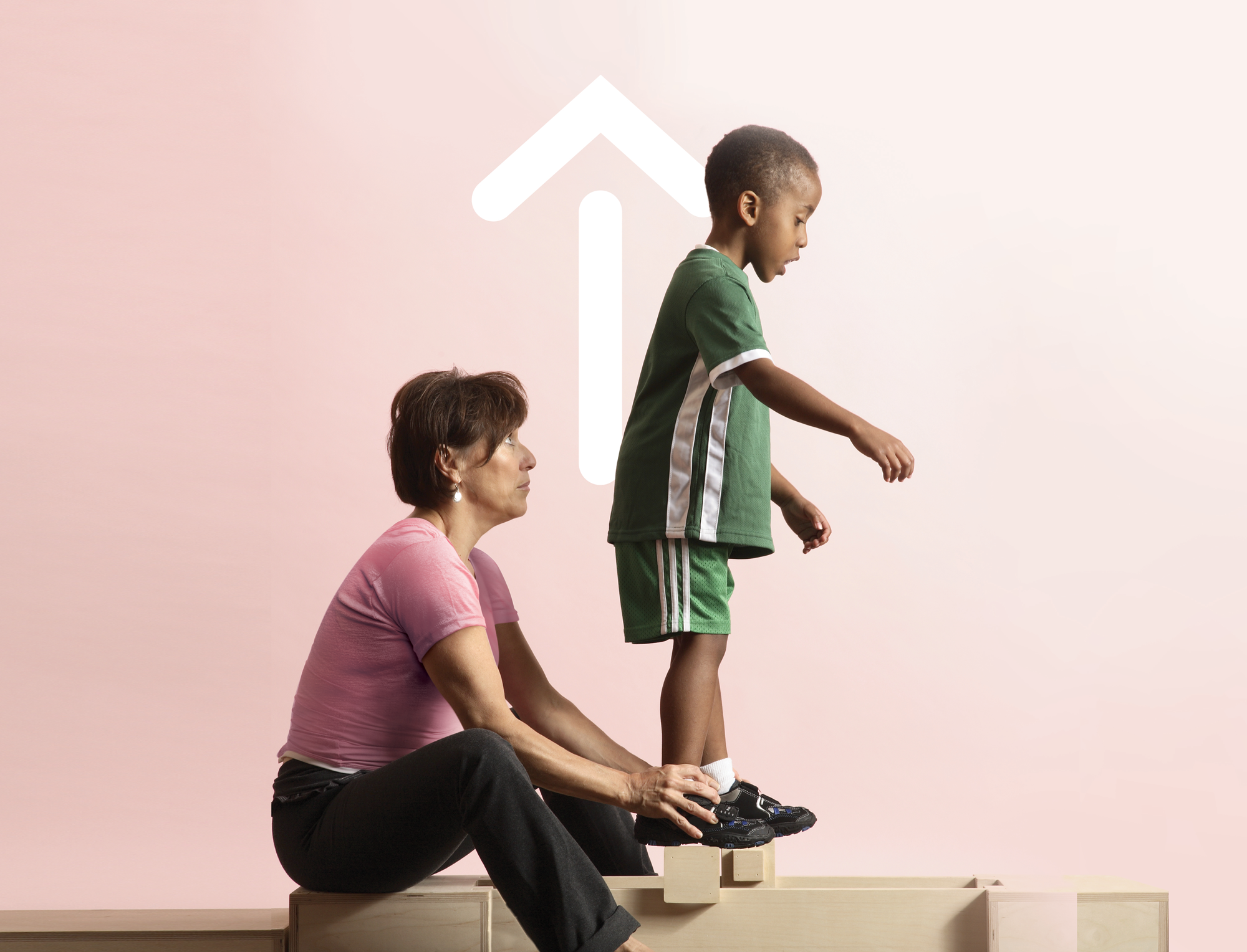 Child being supported during walking exercise with an arrow up in the background