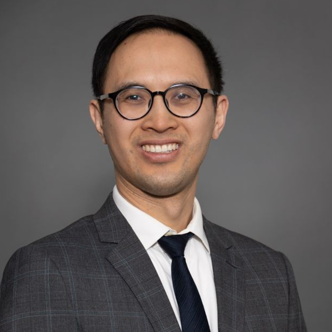 Dr. Jonathan Lai is smiling for his headshot in front of a grey background.