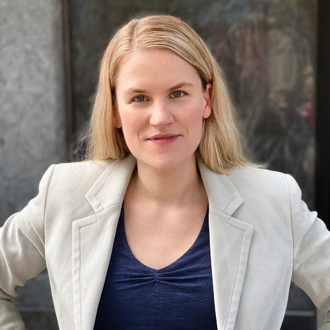 Frances Haugen is standing outside posing for her headshot with her hands on her hips.